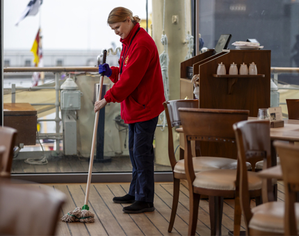 A member of the Housekeeping team mopping the floor of the Tearoom.