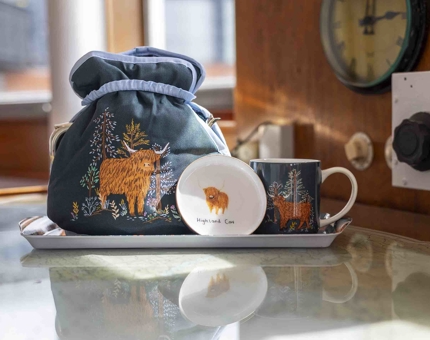 The Coo range of products from the Shop. It includes a tray wit a tea cosy, coaster and mug.